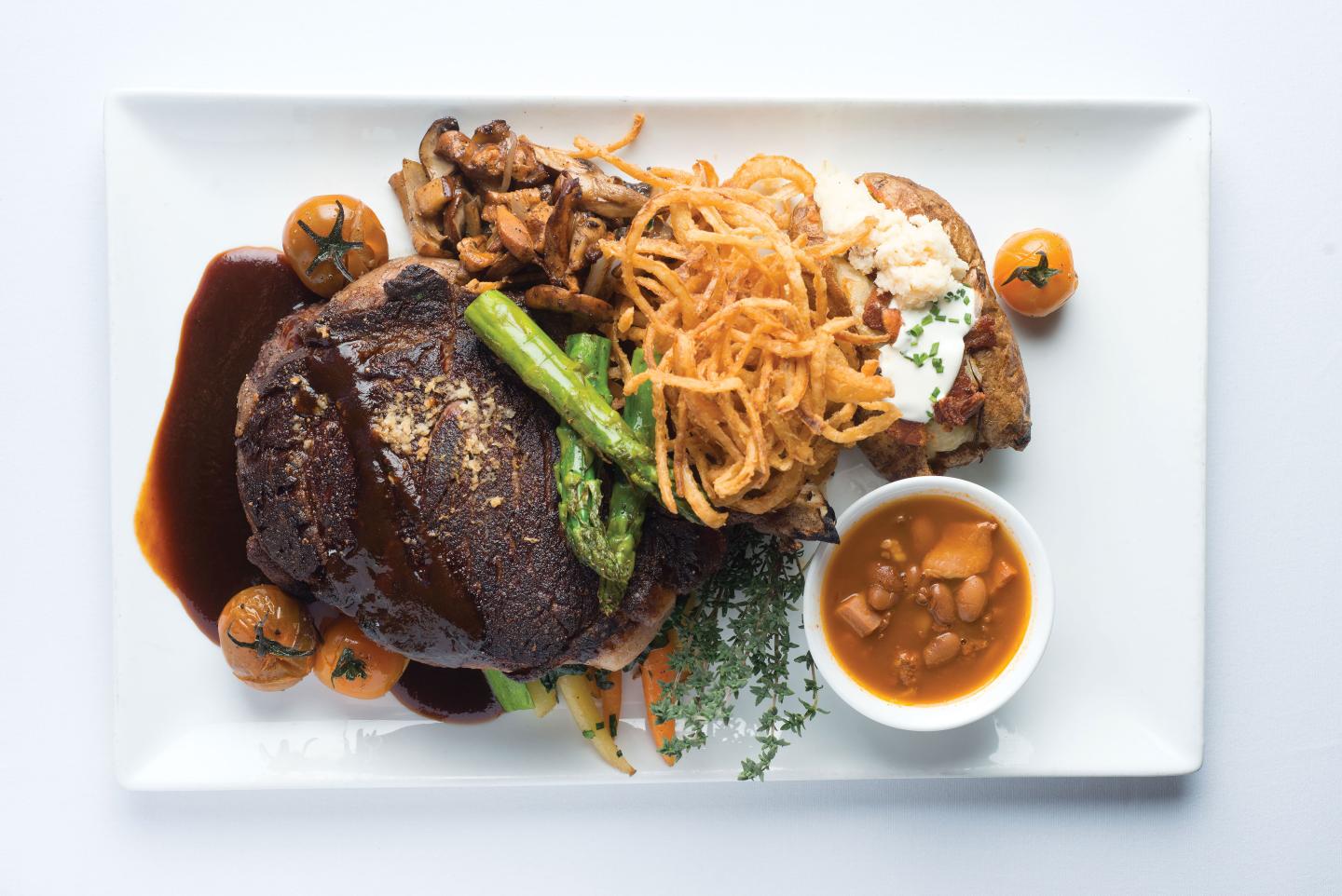 Platos: “Coyote Cafe’s Classic Cowboy Steak with Red Chile Onion Rings”