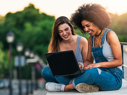 Beautiful women using a laptop in the Street.